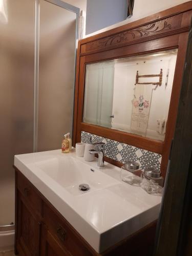 a bathroom with a white sink and a mirror at Kemencés Vendégház in Kővágószőlős