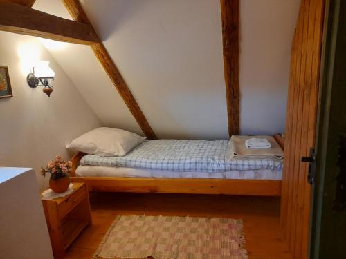 a small bedroom with a bed in an attic at Kemencés Vendégház in Kővágószőlős