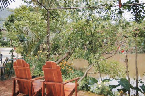 two chairs sitting in front of a garden at Tam Coc Green Haven Retreat in Ninh Binh