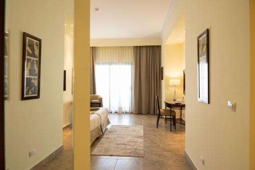 a hotel room with a bed and a dining room at Swiss Inn Plaza Hotel in 6th Of October
