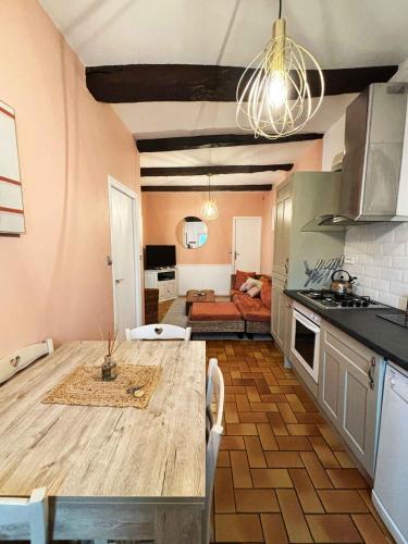 a kitchen with a table and a living room at Emerald Coast Gites and Lodge in Hénansal