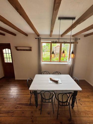 a dining room with a white table and chairs at Emerald Coast Gites and Lodge in Hénansal