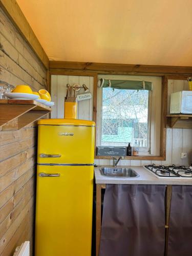 a yellow refrigerator in a kitchen with a sink at Emerald Coast Gites and Lodge in Hénansal