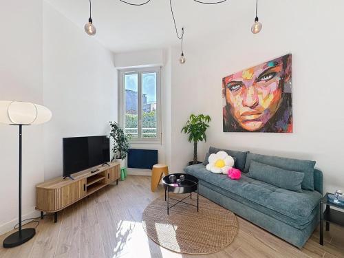 a living room with a blue couch and a painting at Charmant 2P Juan-les-Pins in Antibes