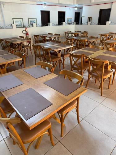 an empty classroom with wooden tables and chairs at Pousada Brisa do Mar in Torres