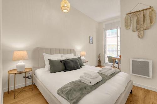 une chambre avec un lit blanc avec des serviettes dessus dans l'établissement Bloom - 12min à pied du Capitole, à Toulouse