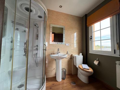 a bathroom with a sink and a shower and a toilet at Pensión Restaurante Tino in Germade