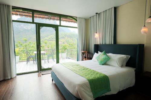 a bedroom with a bed with a view of a patio at Bamboo Hill Resort in Hữu Lũng