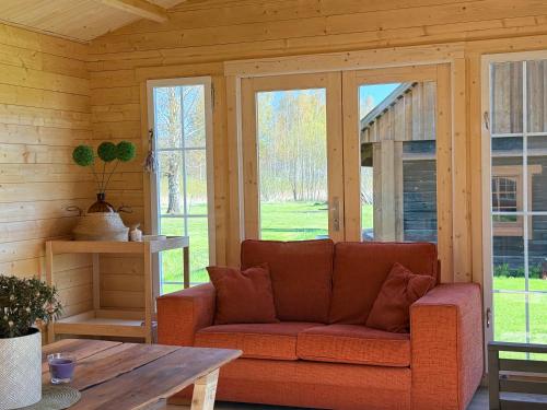 a living room with a couch and a table at Wiire old fishermans farmhouse and smoke sauna in Saulepa