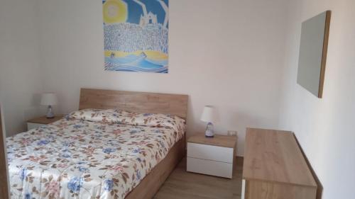 a bedroom with a bed and a painting on the wall at Casa Rosa Forio d'Ischia in Forio d'Ischia