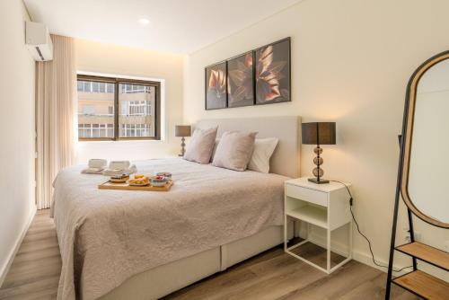 a bedroom with a bed with a tray of fruit on it at Spacious & Stylish Flat with Garage by HostWise in Ermesinde