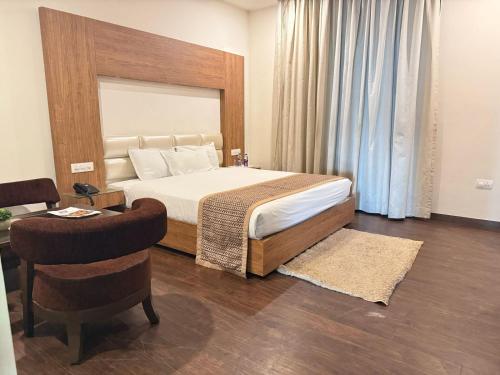 Un dormitorio con una cama, una mesa y una silla. en The Altruist AMR Hotel, en Katra