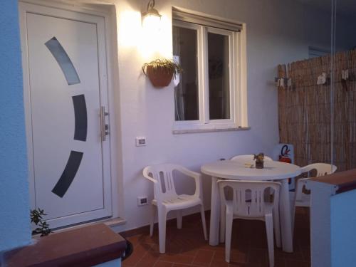 a room with a white table and chairs and a window at Casa Rosa Forio d'Ischia in Forio d'Ischia