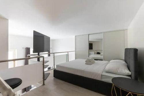 une chambre avec un lit et une télévision à écran plat dans l'établissement Appartement Duplex proche de l'Arc de Triomphe et Trocadero, à Paris