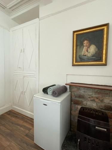 a kitchen with a painting on the wall and a refrigerator at Bryn Awel in Aberystwyth