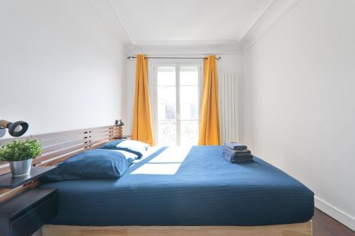 a bedroom with a blue bed and a window at Heart of Paris-1BR-2P-Montparnasse -Free Netflix in Paris