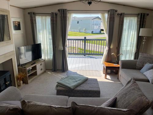 a living room with a couch and a tv at Summer Days at Seven Bays Padstow in Padstow