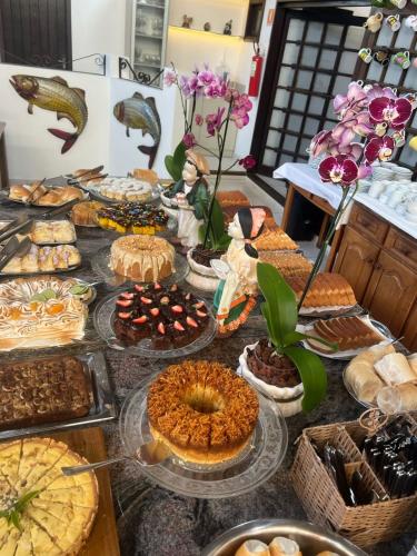 a table with many different types of pies and desserts at Pousada Brisa do Mar in Torres