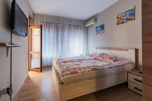 バルチクにあるHoliday Apart 2のベッドとテレビのある寝室