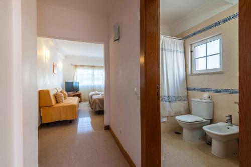 a bathroom with a toilet and a sink in a room at Apartamentos Monte da Vinha I in Albufeira