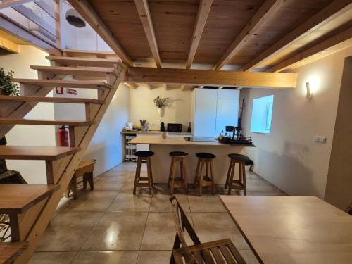 a kitchen with wooden ceilings and bar stools at Beija Rio Charming House in Ferreira do Zêzere