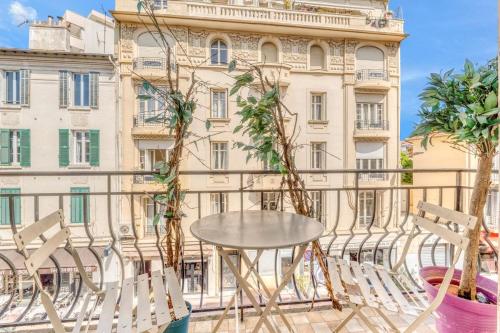 une table et des chaises sur un balcon en face d'un bâtiment dans l'établissement 2 Bed Avenue Saint-jean , 5 minutes from palais des festivals, à Cannes