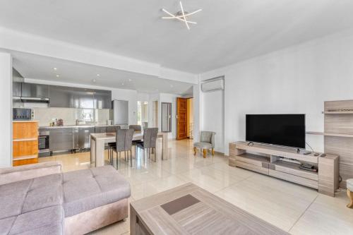 un grand salon avec un canapé et une télévision dans l'établissement 2 Bed Avenue Saint-jean , 5 minutes from palais des festivals, à Cannes