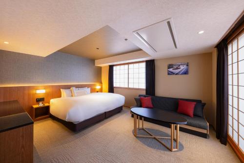 a hotel room with a bed and a couch at Homm Stay Nagi Arashiyama Kyoto By Banyan Group in Kyoto