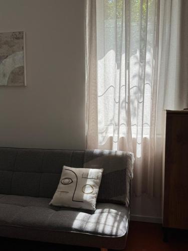 - un canapé avec un oreiller assis devant une fenêtre dans l'établissement Studio dans un Château exceptionnel du 18è siècle, à La Londe-les-Maures