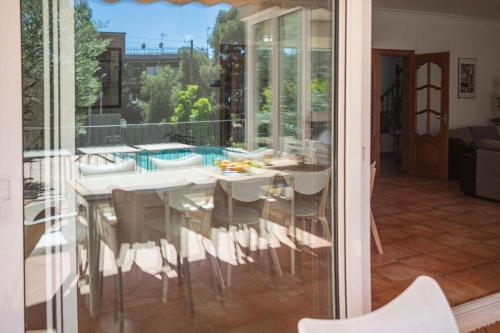 a glass dining room with a table and chairs at Villa espectacular privada con piscina y AACC in Castelldefels