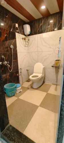 a bathroom with a toilet and a tiled floor at HOTEL PRINCE PALACE in Ratlām