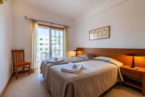 a hotel room with two beds and a window at Apartamentos Monte da Vinha I in Albufeira
