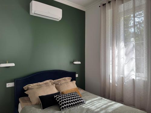 - une chambre avec des murs verts et un lit avec une fenêtre dans l'établissement Studio dans un Château exceptionnel du 18è siècle, à La Londe-les-Maures