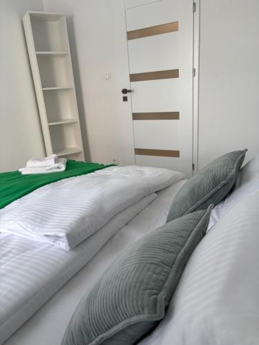 a white bed with two pillows on top of it at Tabago Studio 33 Brzeg Ofiar Katynia in Brzeg