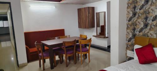 RatlāmにあるHOTEL PRINCE PALACEのテーブルと椅子とベッドのあるダイニングルーム