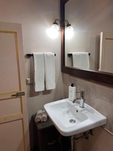 a bathroom with a sink and a mirror and towels at Le Porte del Tempo in Mazara del Vallo