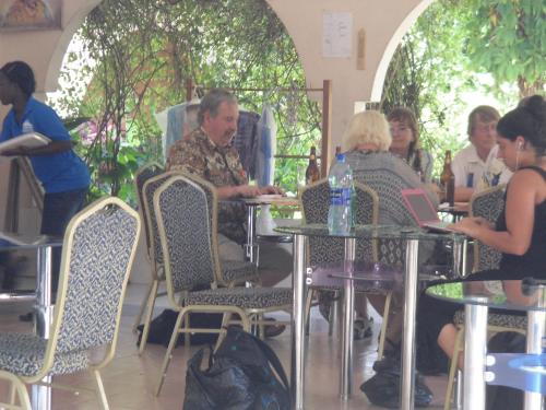 a group of people sitting at tables in a restaurant at Wli Water Heights Hotel in Wli Afegame