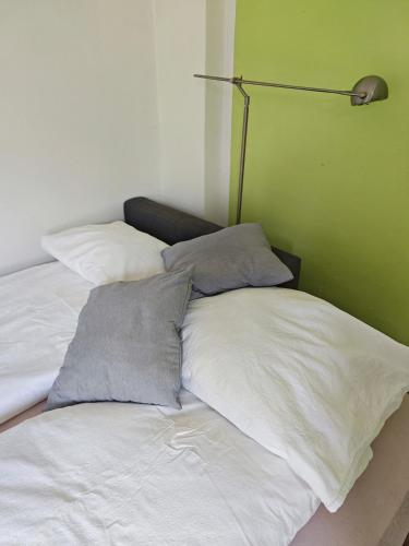a bed with three pillows and a lamp on it at Nettes Schlafzimmer mit Gemeinschaftsbad in zentraler Lage in Bremen