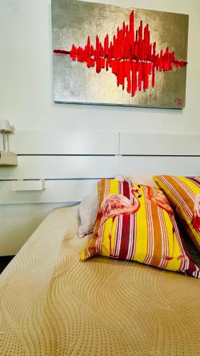 a bed with two pillows and a painting on the wall at Stylish & central #LoftWerk 2 in Velbert