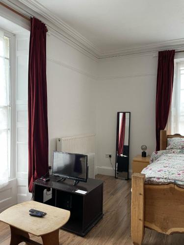 a bedroom with a bed and a tv on a table at Bryn Awel in Aberystwyth