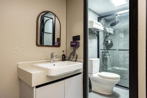 a bathroom with a sink and a toilet and a shower at Shanghai Zhuzhu Hotel - 24-hour free airport pick-up and drop-off at Pudong Airport in Shanghai