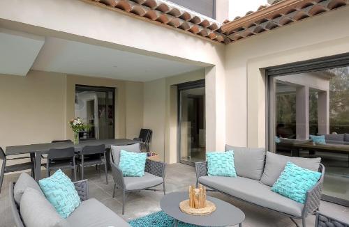 une terrasse avec des canapés, une table et des chaises dans l'établissement Beautiful Villa Mougins quiet heated pool, à Mougins