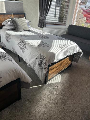 a bedroom with two beds and a couch at Milton Lodge in Weston-super-Mare