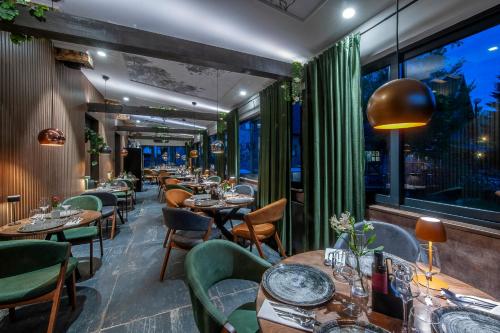 a restaurant with tables and chairs and large windows at Lakeside Hotel Plitvice in Plitvička Jezera