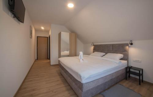 a bedroom with a large white bed and a television at Villa Old Hills by Villas Guide in Ljubešćica