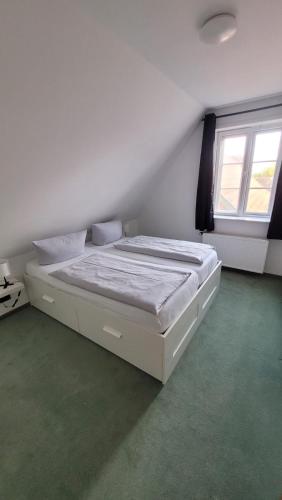 a white bed in a room with a window at Hotel Zur Linde in Meldorf