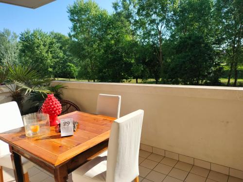 a wooden table and chairs on a patio with trees at Maison Papà, una casa per sentirsi a casa. in Vicenza