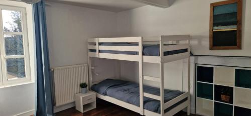 une chambre avec deux lits superposés et une fenêtre dans l'établissement Maison de charme en Bretagne 5 ou 10 personnes, à Châteaugiron