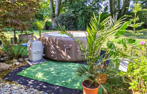 a garden with a hot tub and a green lawn at Beautiful Home In Charritte-De-Bas in Charritte-de-Bas