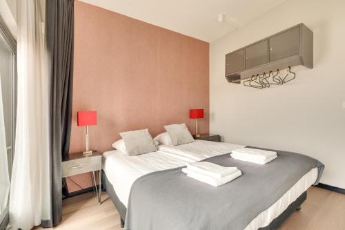 a bedroom with a bed with a tv on the wall at Hotel Zilt in Vlissingen
